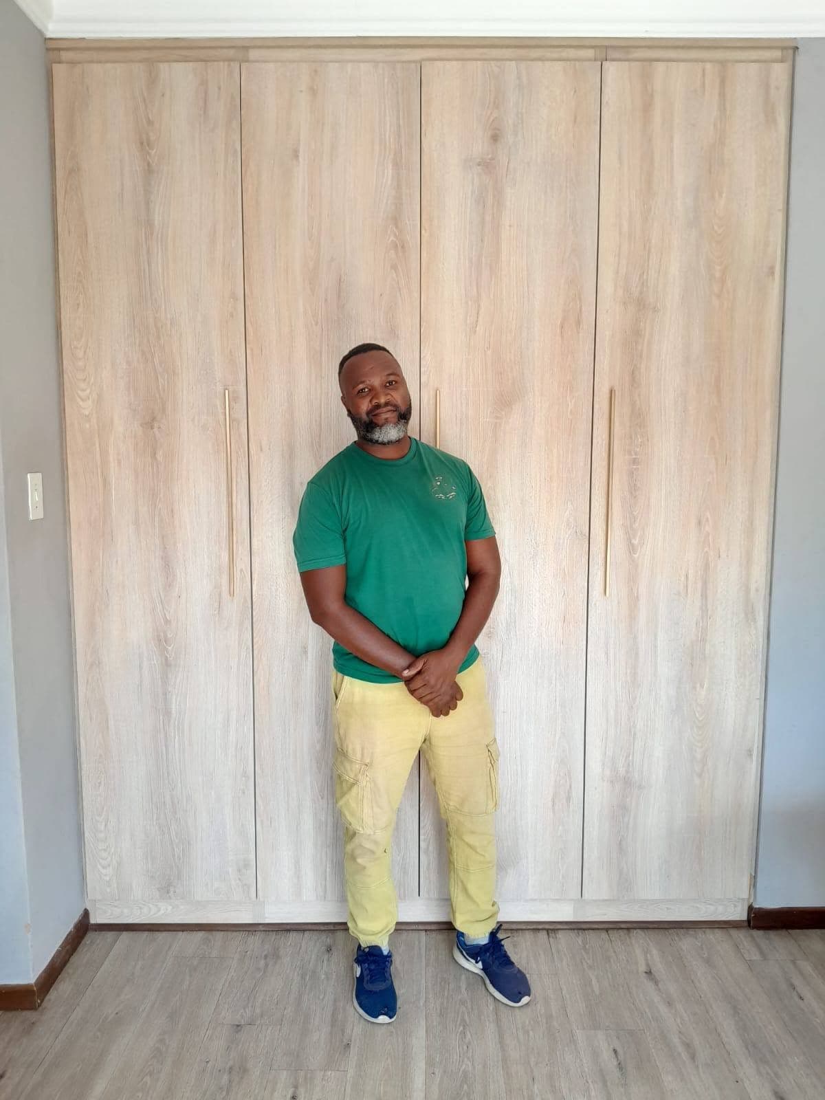 Koki Motsene, owner of Home of Carpentry, in front of a fitted wardrobe he built